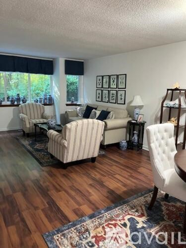A living room with a striped chair and a white chair.