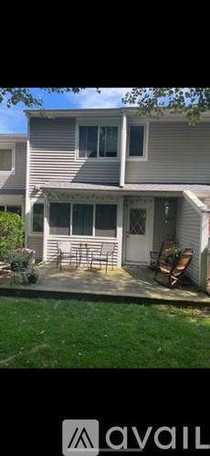 A house with a grey siding and a white door is shown.