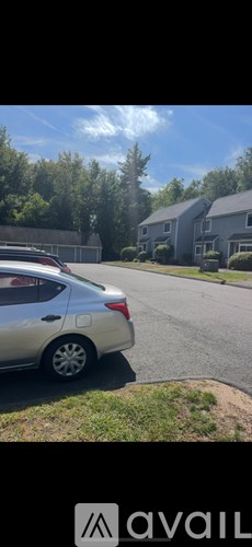 A silver car is parked on the side of a road.
