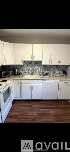 A living room with a grey couch, a black coffee table, and a lamp.