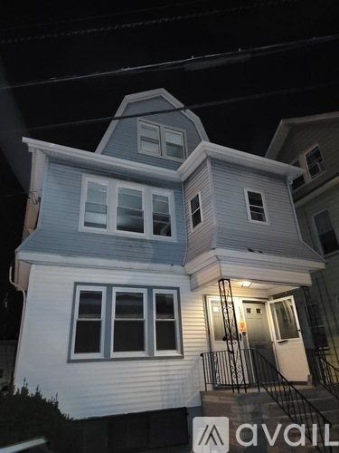 A two-story house with a balcony and a staircase leading to the front door.