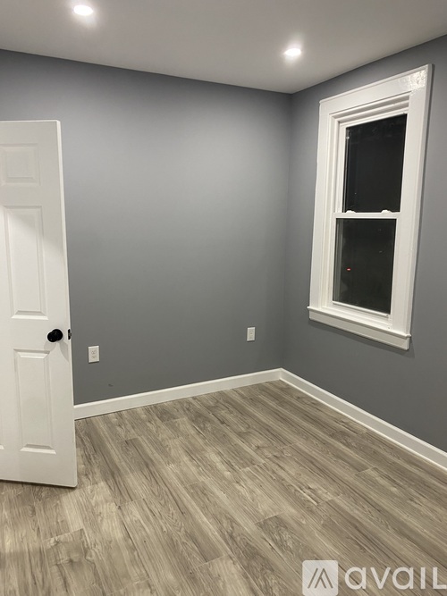 A room with a white door and a window with a white frame.