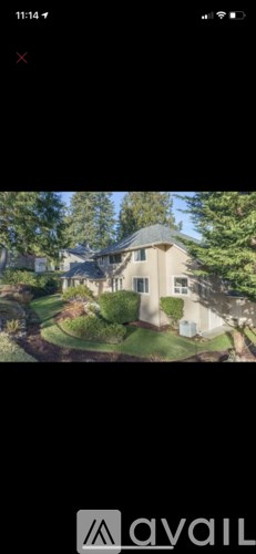 A house with a well-manicured lawn and trees in the background.