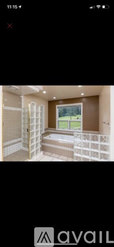 A room with a bed and a window overlooking a green field.