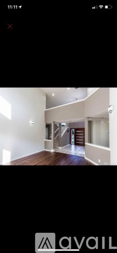 A modern, empty living space with a staircase leading to the upper level.