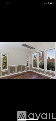 A room with a large window and a wooden floor.