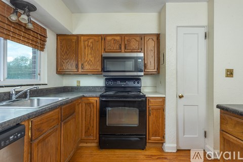 A kitchen with wooden cabinets and a black stove top oven.