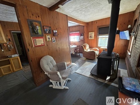 A living room with a wood-burning stove and a chair.