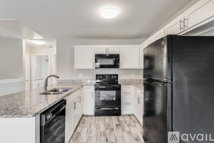 A kitchen with black appliances and white cabinets.