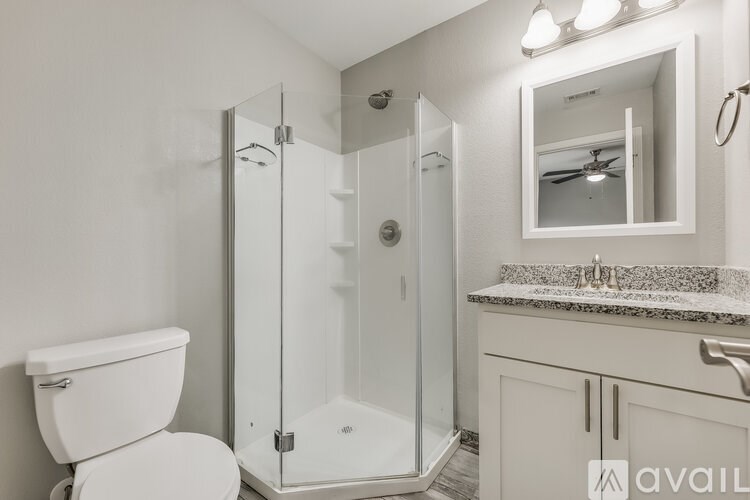 A bathroom with a toilet, sink, and shower.