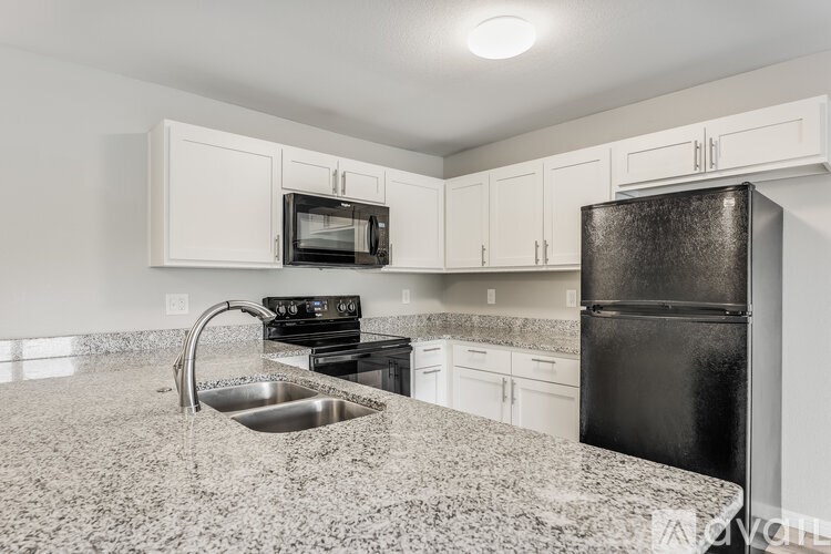 A kitchen with granite countertops and white cabinets.