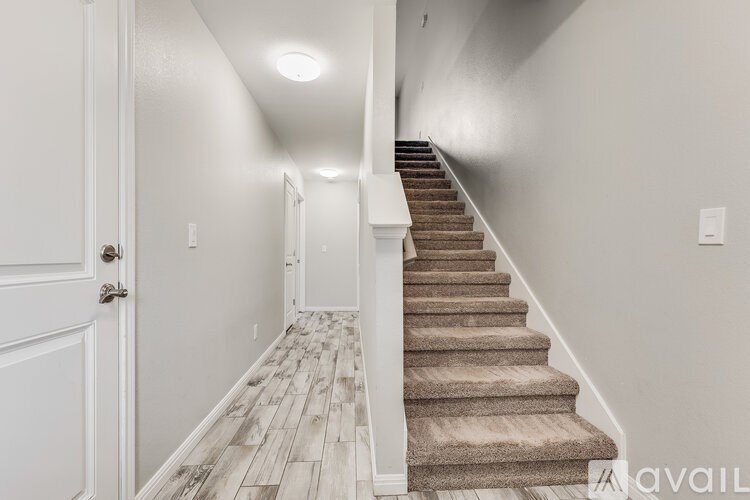 A hallway with a staircase and a door.
