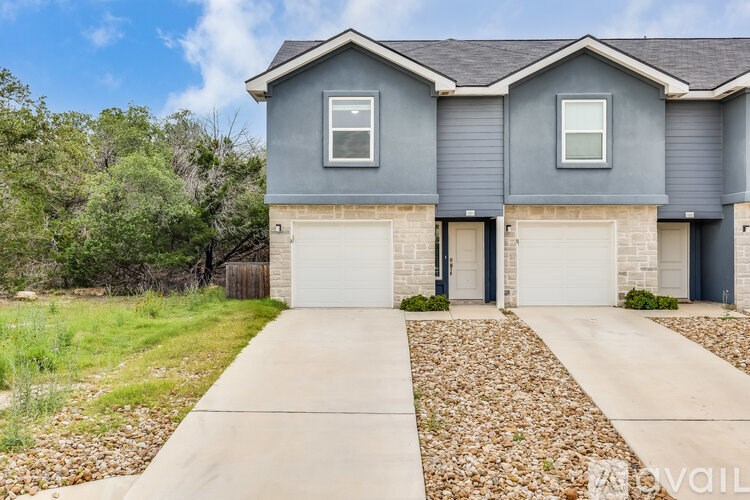A house with a grey exterior and a white garage door.