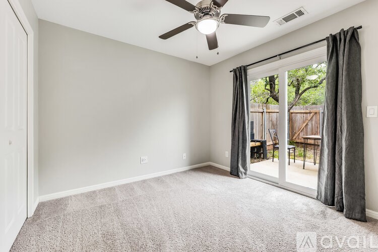 A room with a ceiling fan and carpeted floor.