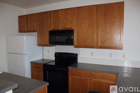 A kitchen with a black oven and white fridge.