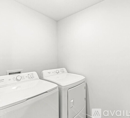 Two white front loading washing machines in a laundry room.