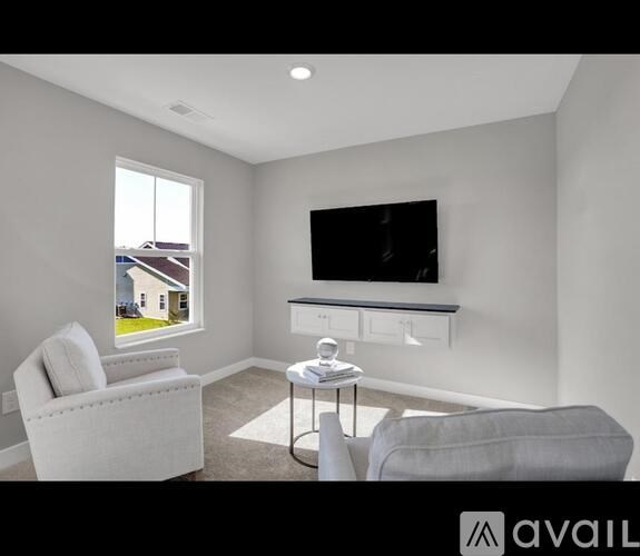A living room with a television, a chair, and a table.