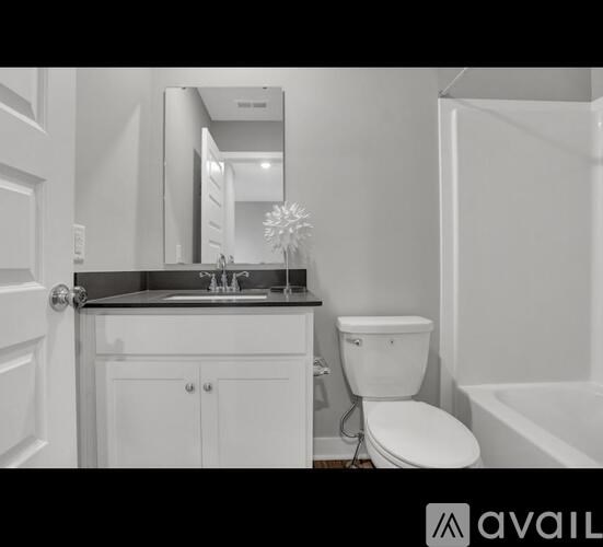 A white bathroom with a toilet, sink, and mirror.