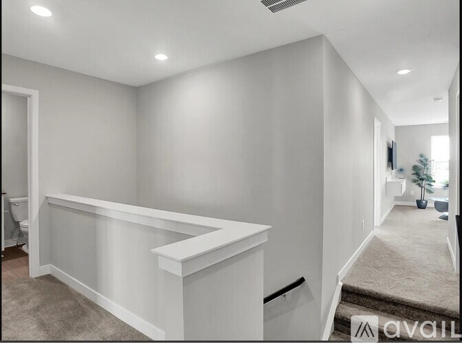 A white room with a carpeted floor and a wall-mounted television.