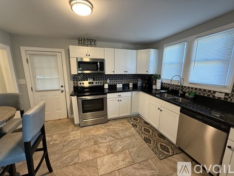 A kitchen with a tile floor and a sign that says "HAPPY" on the wall.