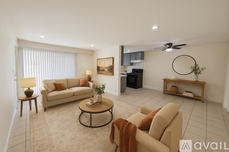 A living room with a beige couch, a coffee table, and a ceiling fan.