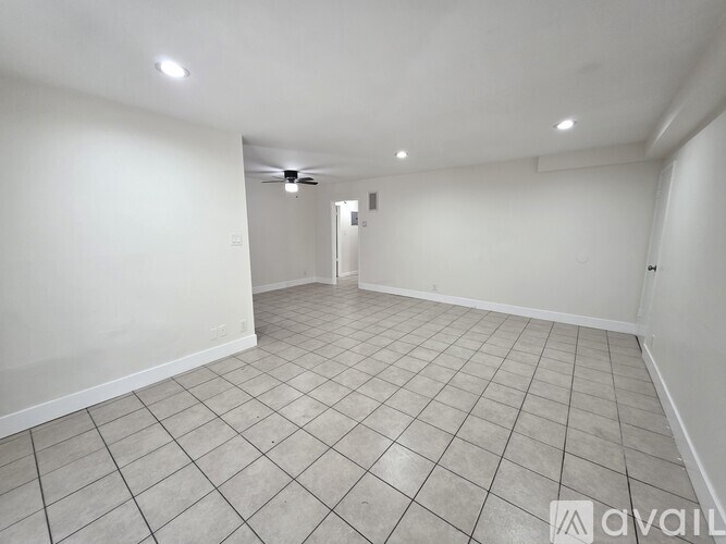 A spacious room with a tiled floor and a ceiling fan.