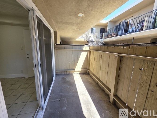 A room with a slanted ceiling and a staircase in the background.