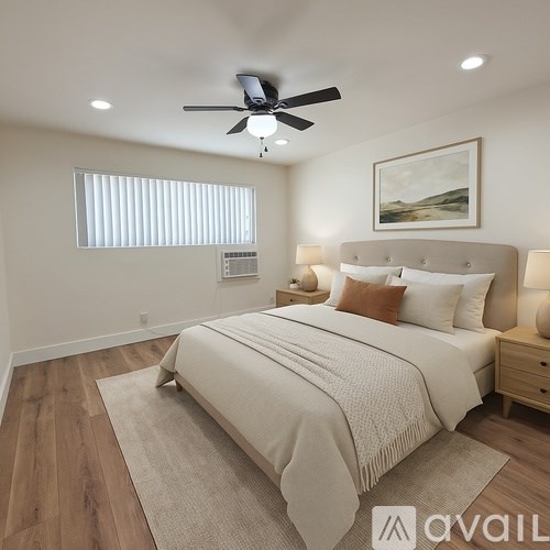A bedroom with a large bed and a ceiling fan.