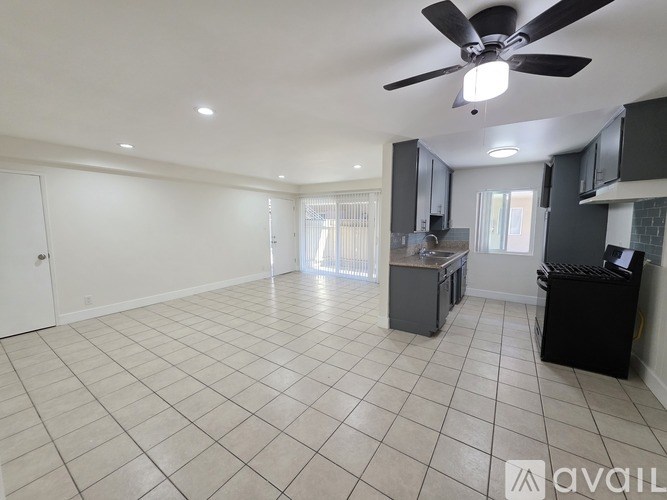 A spacious room with a ceiling fan and tiled flooring.