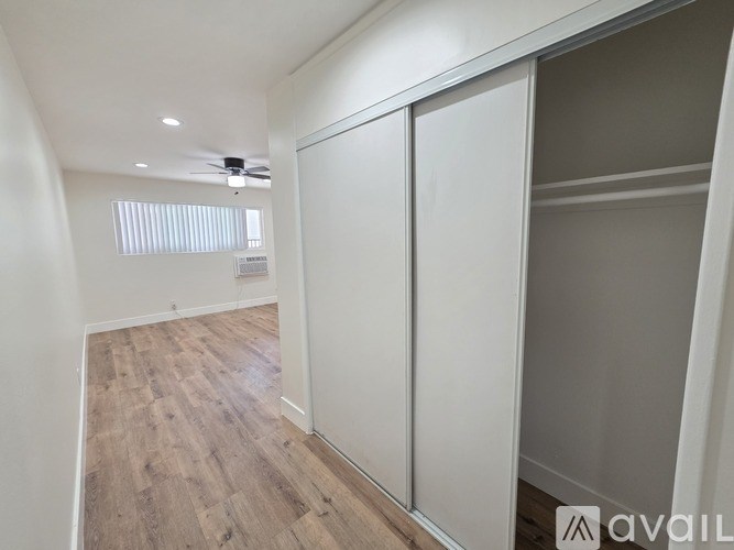 A room with a sliding door and wooden flooring.