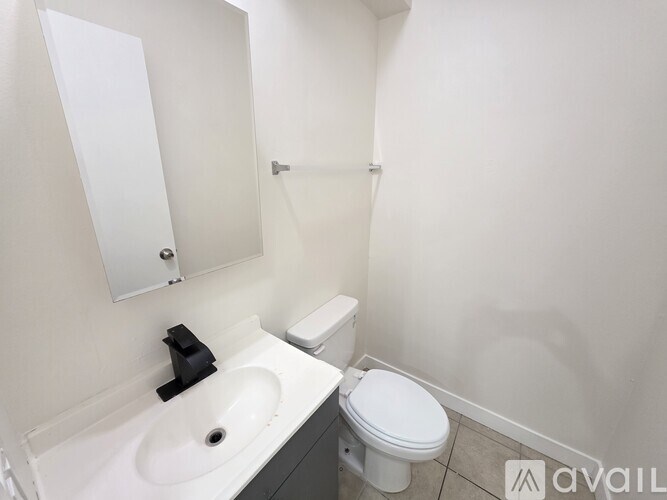 A white toilet sits next to a sink in a small bathroom.