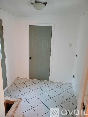 A room with a door and tiled floor.