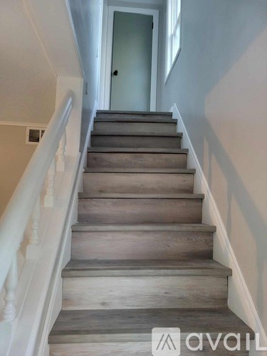A staircase with wooden steps and white railings.