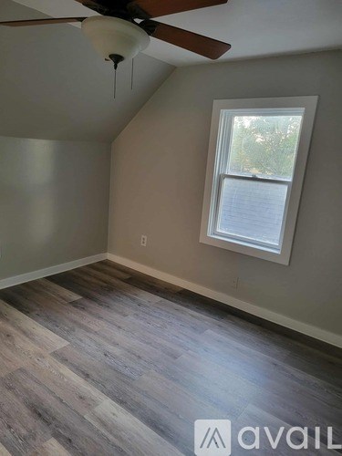 A room with a ceiling fan and a window.