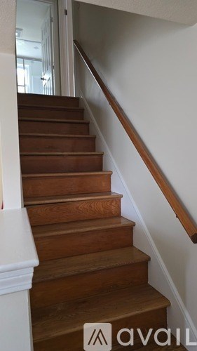 A staircase with wooden steps and a white balustrade.
