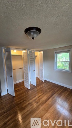 A room with a window and a wooden floor.