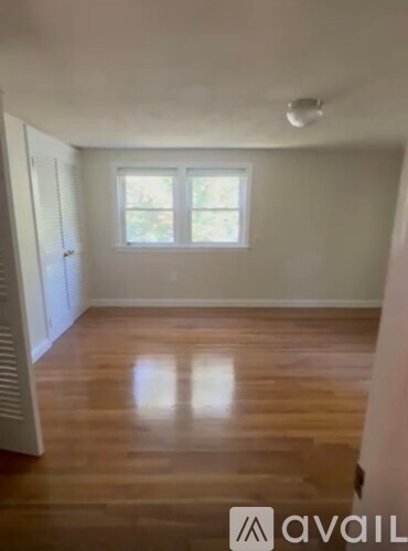 A room with wooden flooring and a window.