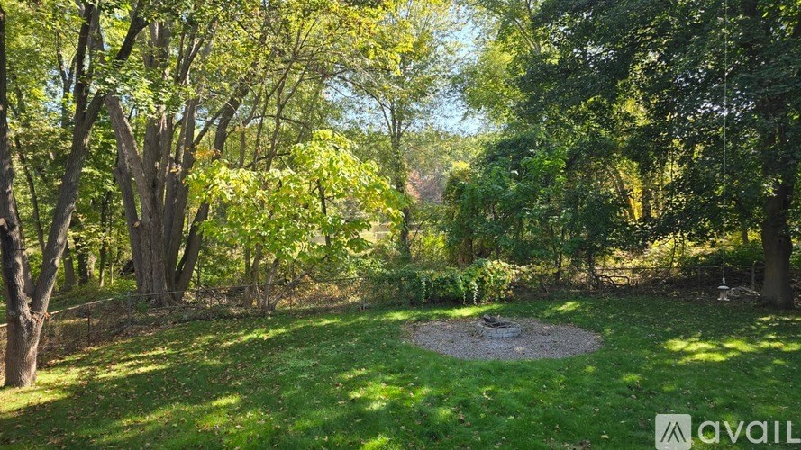 A lush green garden with a circular stone structure in the middle.