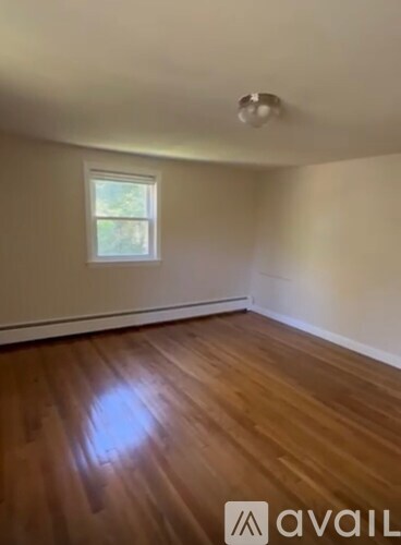 A room with wooden flooring and a window.