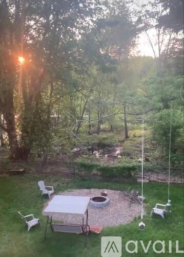 A backyard with a table and chairs and a swing set.