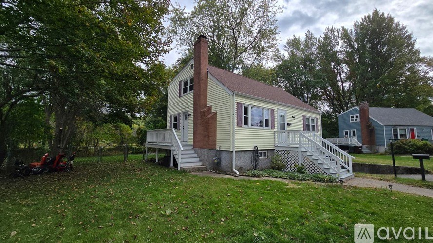 A house with a red motorcycle parked in front of it.