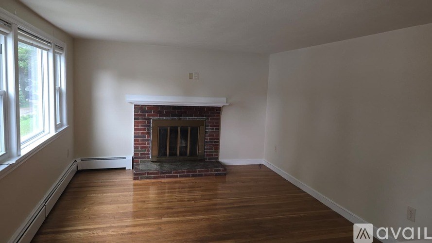 A room with a fireplace and wooden floors.
