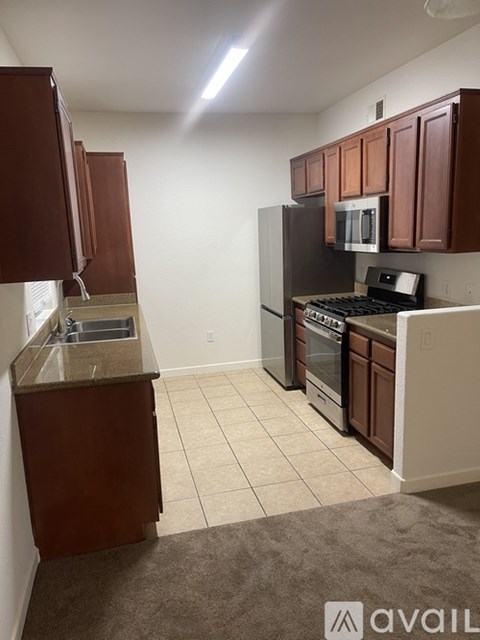 A kitchen with brown cabinets and a black stove top oven.