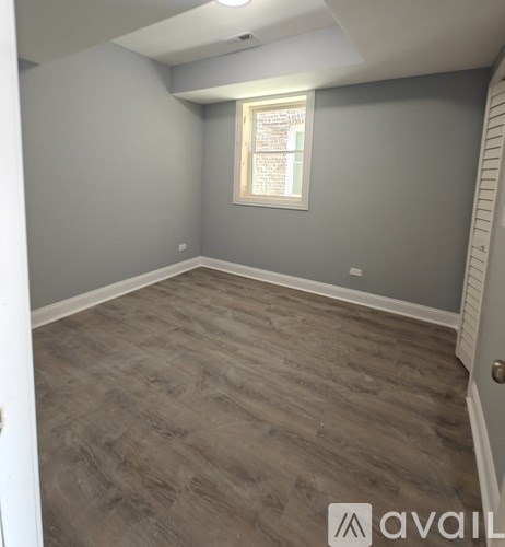 A room with grey walls and a window with white blinds.