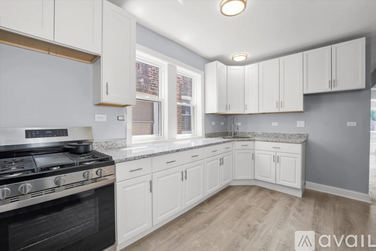 A kitchen with white cabinets and a black stove top.