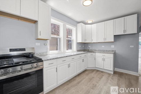 A kitchen with white cabinets and a black stove top.