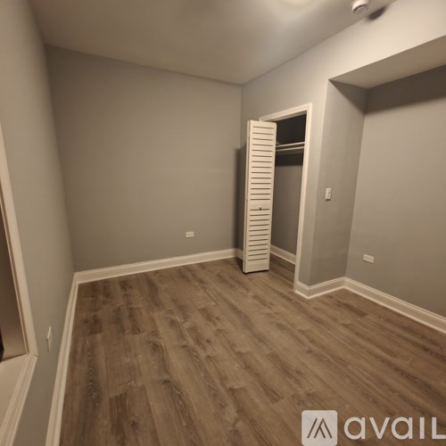 A room with wooden flooring and a white door.