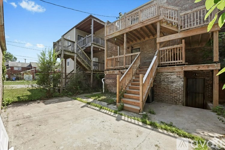 A large, multi-level wooden house with a balcony and staircase.