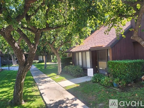 A tree-lined pathway leads to a house.