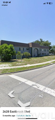 A street view of Eastbrook Blvd with a house and a street sign.